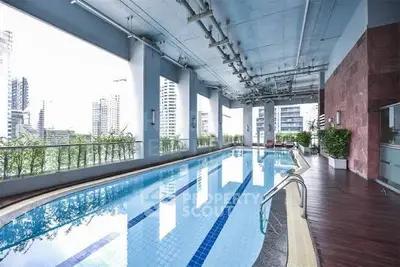Luxurious high-rise building with rooftop pool offering stunning city views and modern amenities.