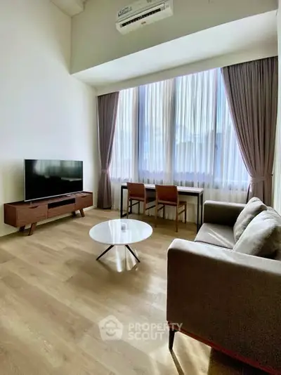 Modern living room with high ceiling, large window, and stylish furniture.