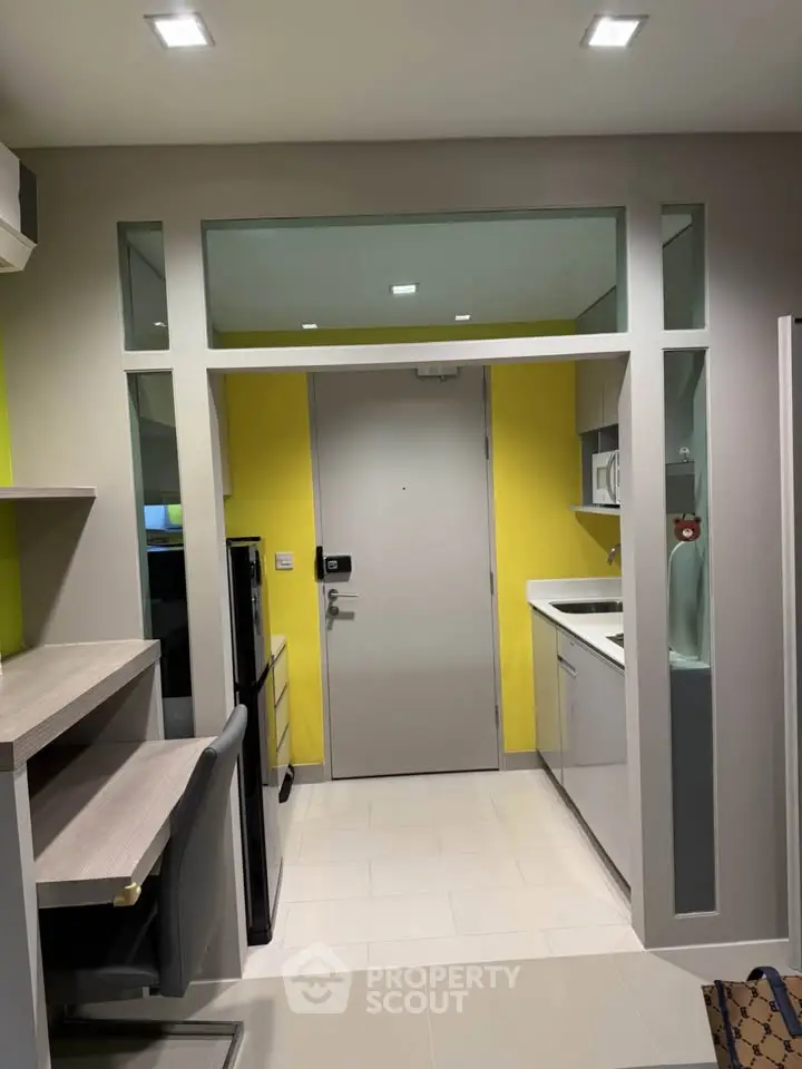 Modern compact kitchen with sleek design and vibrant yellow accent wall
