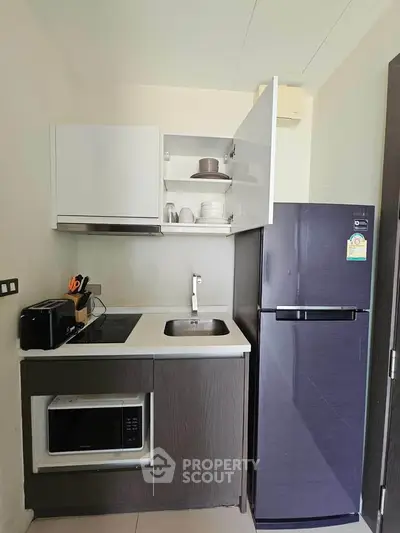 Modern compact kitchen with sleek appliances and efficient storage solutions.