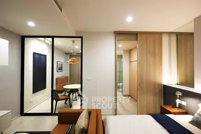 Modern bedroom with stylish decor and adjacent dining area in a contemporary apartment.