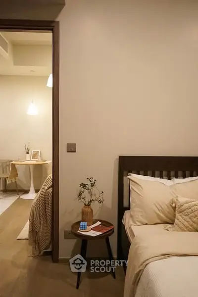 Cozy bedroom with neutral tones and modern decor, featuring a stylish bedside table and inviting ambiance.
