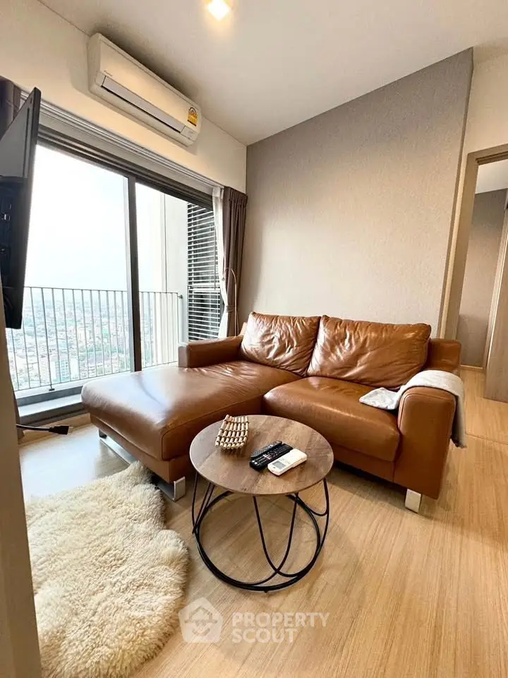 Stylish living room with leather sofa and city view balcony in modern apartment.