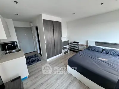 Modern studio apartment with sleek design and compact kitchen area, perfect for urban living.