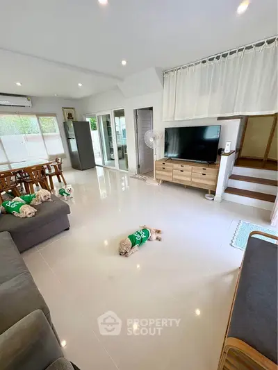 Spacious modern living room with sleek furniture and natural light, perfect for family gatherings.