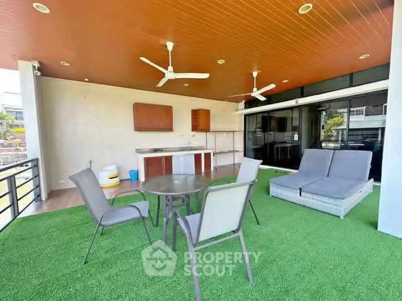 Spacious balcony with outdoor seating and artificial grass flooring