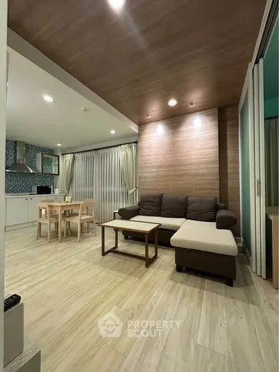 Modern open-layout living room with cozy seating and stylish kitchen area, perfect for entertaining.