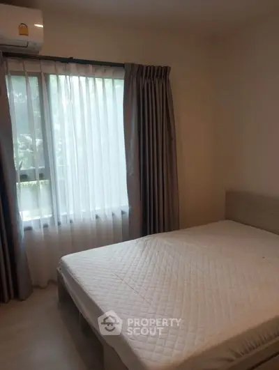 Cozy bedroom with natural light and modern furnishings, perfect for relaxation and comfort.