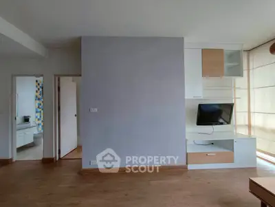 Modern living room with built-in TV unit and wooden flooring