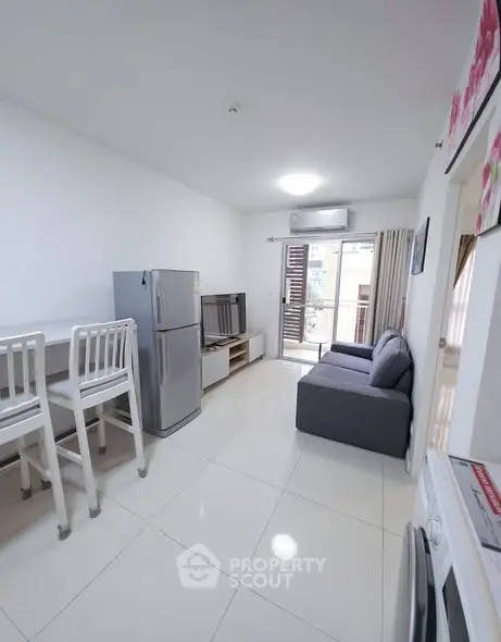 Modern living room with open layout, featuring a sleek kitchen and cozy seating area.