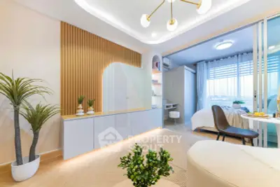 Modern living room with stylish decor and open layout leading to a cozy bedroom, featuring elegant lighting and plants.