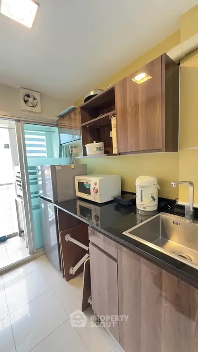 Modern kitchen with sleek cabinets and appliances, featuring a compact design and ample storage space.