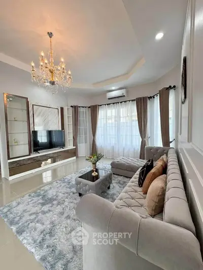 Luxurious living room with elegant chandelier and plush seating in modern home.