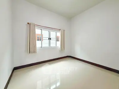 Spacious empty room with large window and tiled floor, perfect for customization.