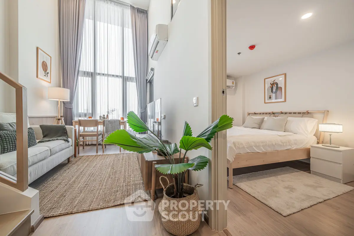 Modern apartment interior with cozy living room and stylish bedroom, featuring natural light and elegant decor.