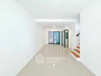 Spacious modern living room with sleek tile flooring and glass partition