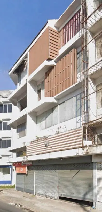 Commercial building exterior with closed shutters and modern facade design.