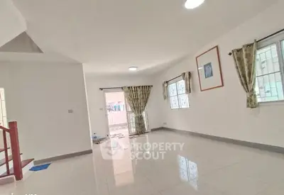 Spacious living room with large windows and modern tile flooring