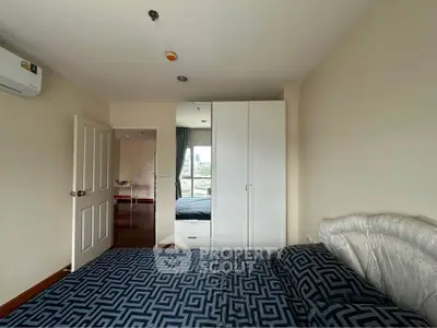 Spacious bedroom with modern decor and ample natural light in a stylish apartment.