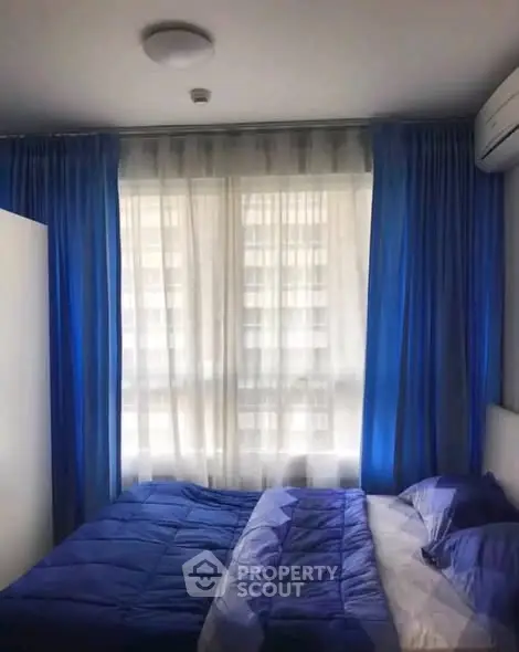 Cozy bedroom with blue curtains and twin beds, perfect for restful nights.