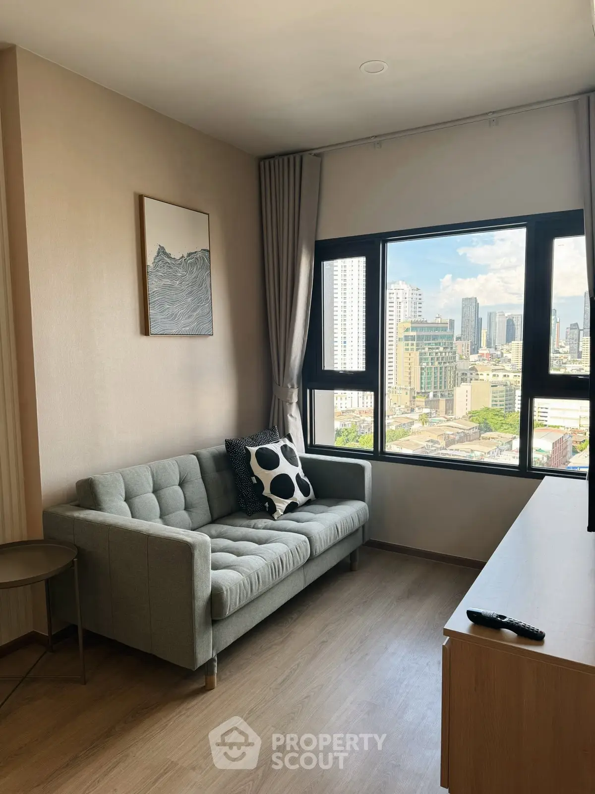 Modern living room with city view, featuring a stylish sofa and large window.