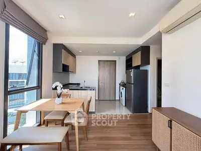 Modern kitchen and dining area with natural light and sleek appliances.
