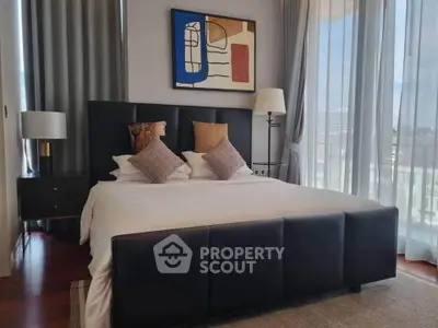 Modern bedroom with stylish decor and large windows offering natural light.