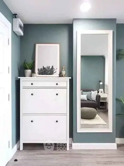 Stylish modern interior with white dresser and large mirror in a cozy living space.