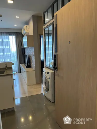 Modern apartment interior with washing machine and open layout kitchen