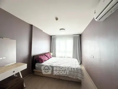 Cozy bedroom with natural light, featuring a bed, air conditioning, and a stylish dresser.