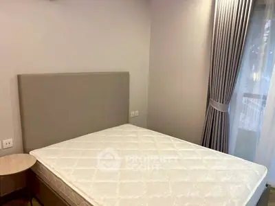 Cozy bedroom with elegant curtains and a comfortable bed in a modern apartment.