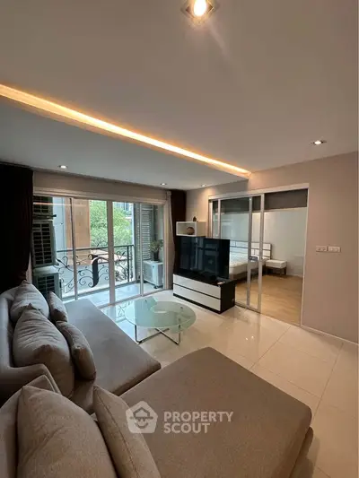 Modern living room with elegant sofa, glass coffee table, and balcony view in stylish apartment.