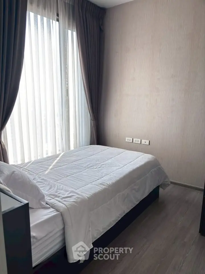 Cozy bedroom with natural light and modern decor, perfect for relaxation and comfort.