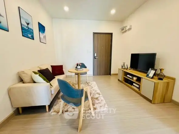 Modern living room with cozy sofa, stylish decor, and flat-screen TV in a bright apartment.