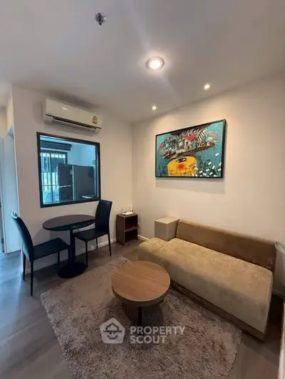 Cozy living room with modern decor and air conditioning, perfect for relaxation.