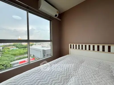 Cozy bedroom with large window offering a scenic view, featuring a comfortable bed and air conditioning.