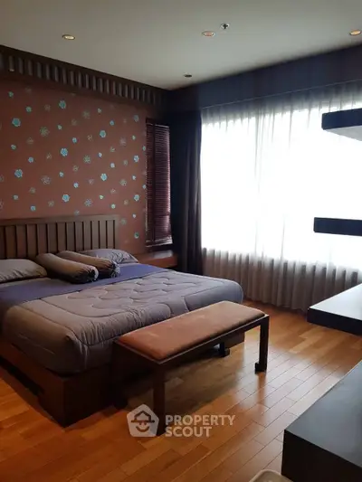 Spacious bedroom with modern decor and large window for natural light