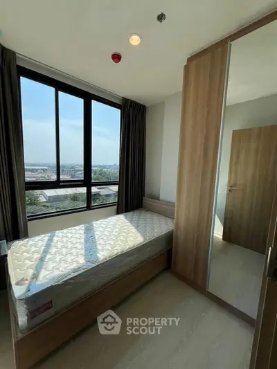 Modern bedroom with large window and built-in wardrobe offering scenic views.