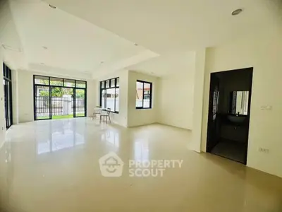 Spacious modern living room with large windows and natural light