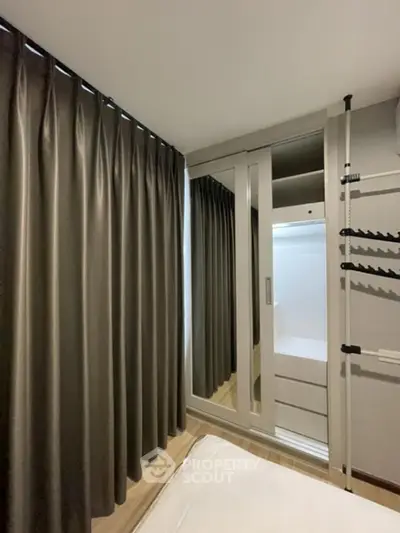 Modern bedroom with mirrored wardrobe and elegant curtains