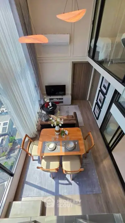 Stunning high-ceiling living room with modern dining area and large windows offering a breathtaking view.