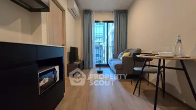 Modern living room with balcony, cozy sofa, and stylish decor in a contemporary apartment.