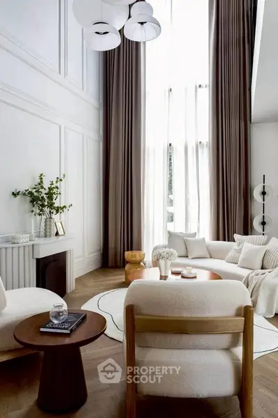 Luxurious living room with high ceilings, elegant decor, and large windows for natural light.