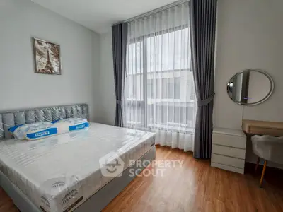 Modern bedroom with large window and stylish furnishings