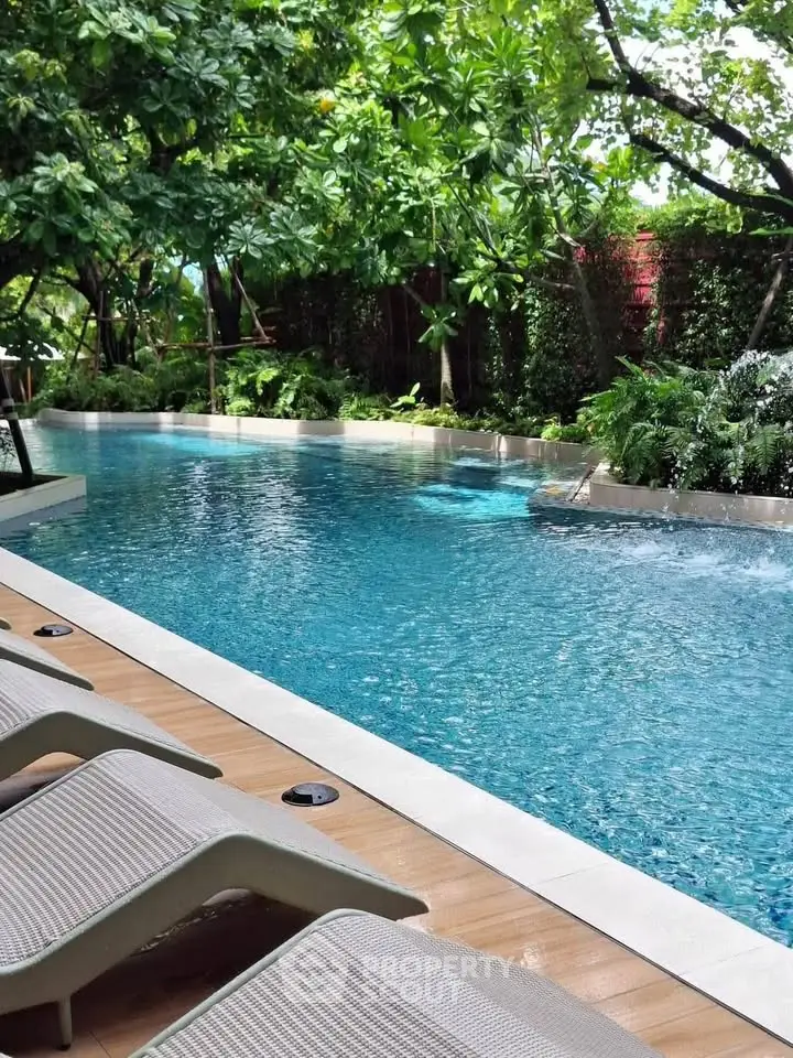 Luxurious outdoor pool surrounded by lush greenery, perfect for relaxation and leisure in a serene environment.