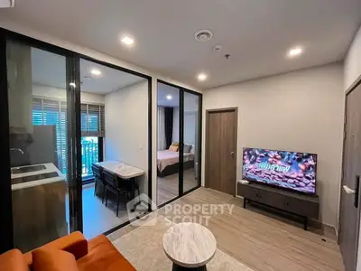 Modern apartment interior with open living room and bedroom, featuring stylish furniture and natural light.