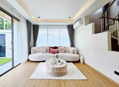 Modern living room with elegant decor and natural light, featuring a cozy sofa and stylish coffee table.