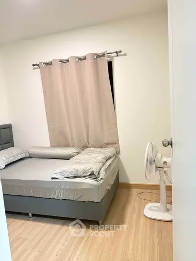 Cozy bedroom with modern decor and natural light, featuring a comfortable bed and stylish curtains.