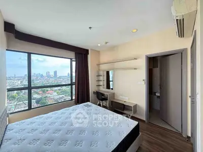 Spacious bedroom with stunning city view and modern furnishings.