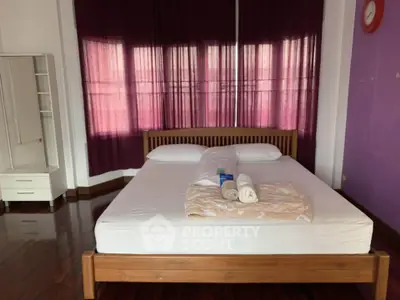 Spacious bedroom with wooden bed frame and elegant decor